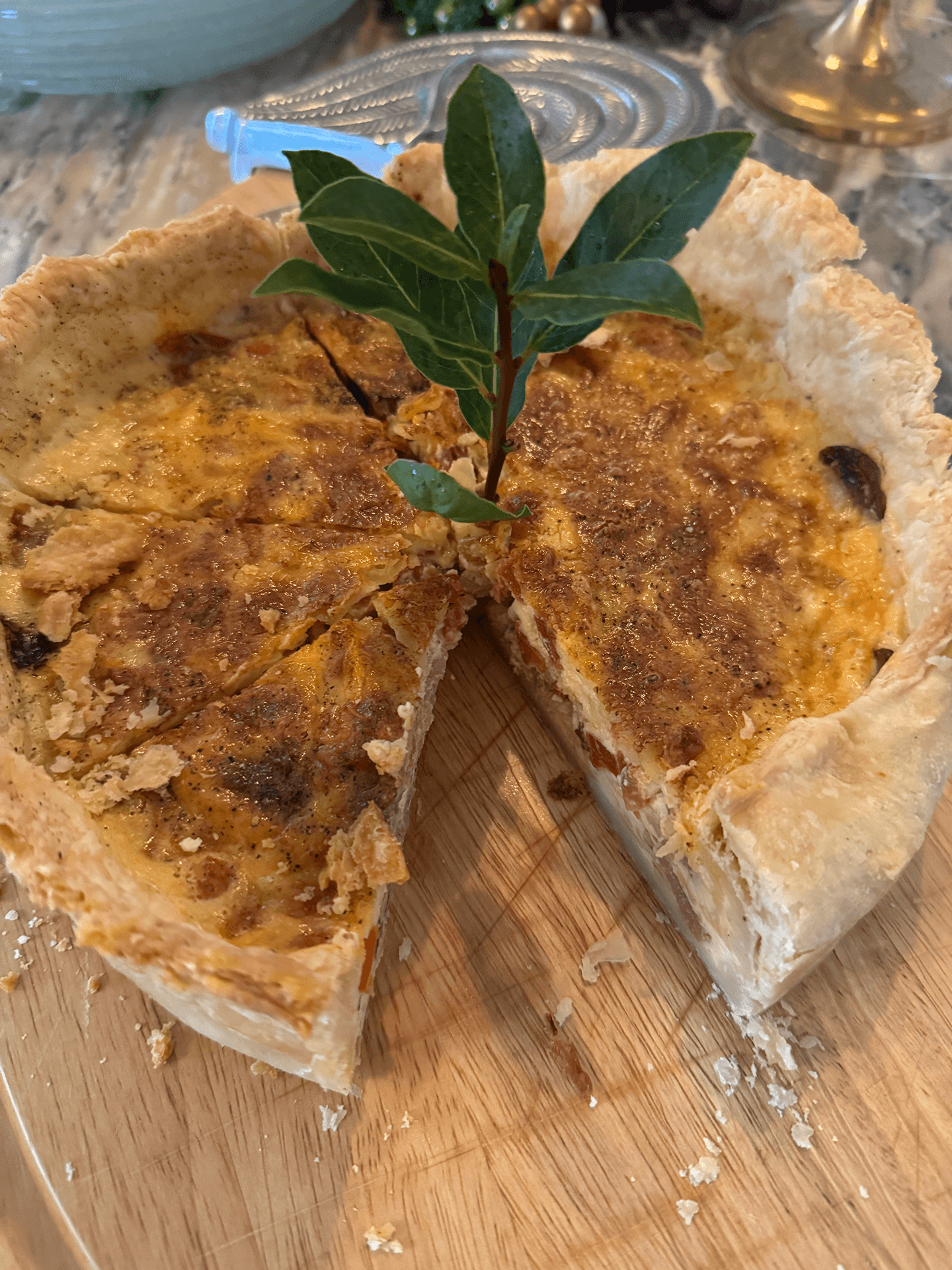 A sliced savory pie garnished with a bay leaf.